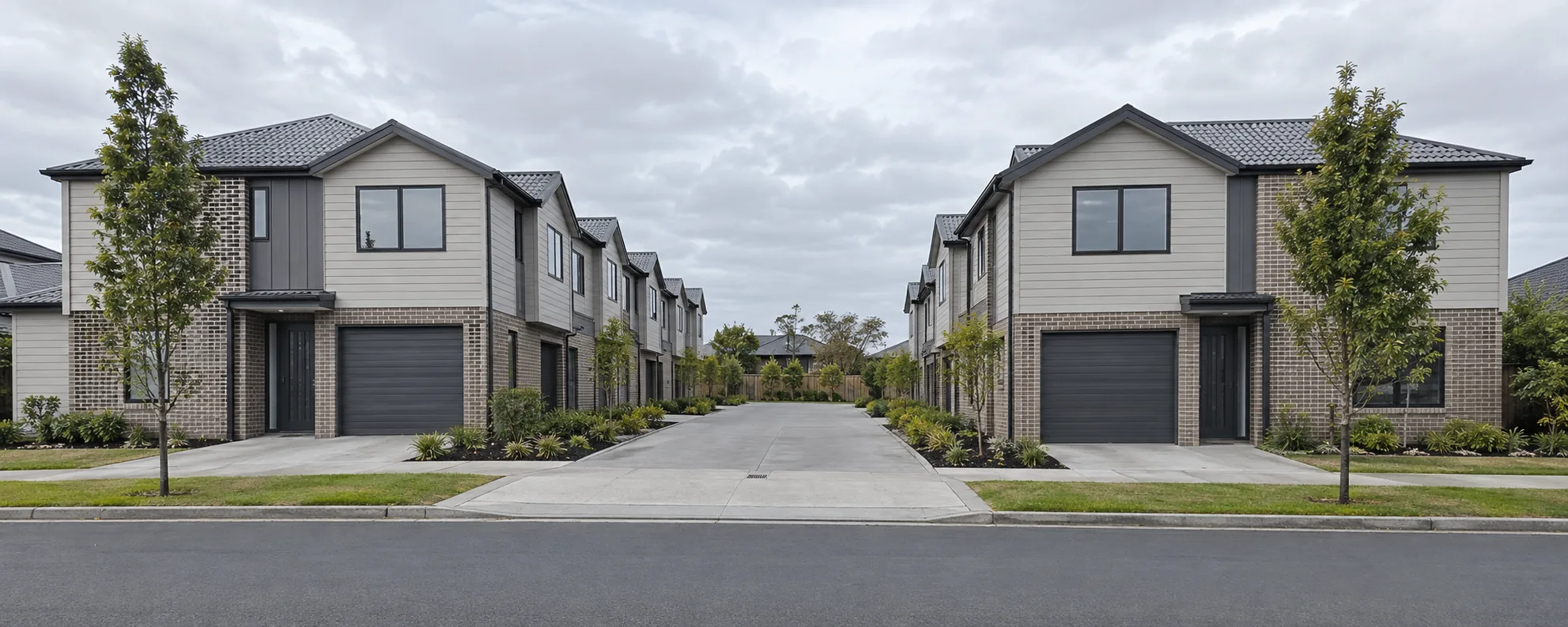 Recently built two storey townhouses in mixed cladding with garages to a shared drive, the kind of home 21% of Manurewa built since 2015